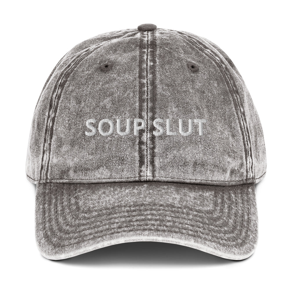 Gray soup slut hat - Are you a soup slut? Looking for a funny gift for a soup enthusiast? Our Soup Slut Hat is just what you need. It's comfortable, has an adjustable closure, and comes in a variety of colors with "Soup Slut", expertly embroidered on the front. Eat your favorite soups and add a little personality to your everyday style. Celebrate your favorite foods in our funky foodie clothing and accessories.