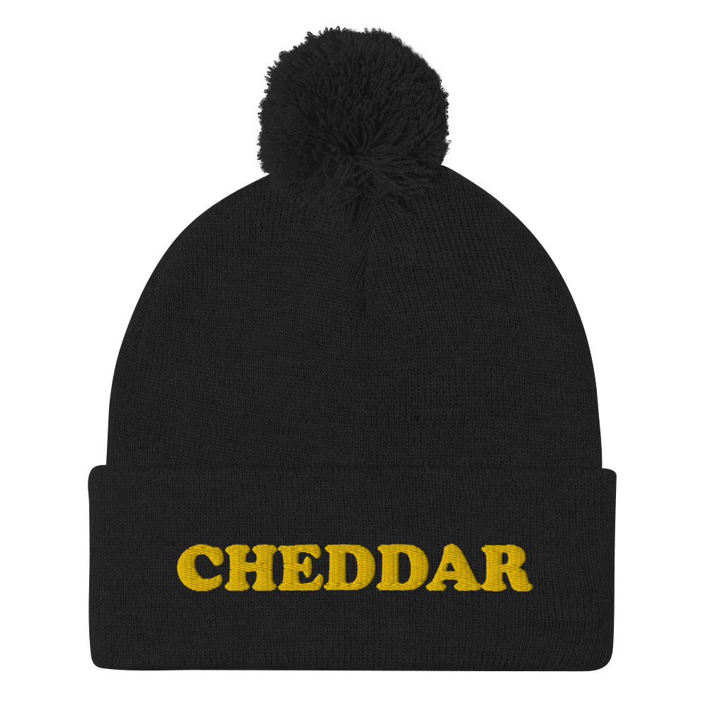 Black Do you love cheddar cheese? Looking for a funny foodie gift? This warm and cozy, embroidered beanie is just what you need. It's a classic pom pom beanie with "Cheddar", expertly embroidered on the front. The perfect funny beanie for cheese lovers, cheddar enthusiasts and foodies of all kinds.