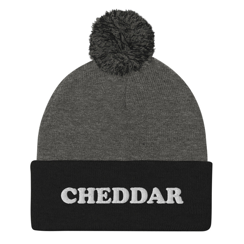 Black and Gray Do you love cheddar cheese? Looking for a funny foodie gift? This warm and cozy, embroidered beanie is just what you need. It's a classic pom pom beanie with "Cheddar", expertly embroidered on the front. The perfect funny beanie for cheese lovers, cheddar enthusiasts and foodies of all kinds.