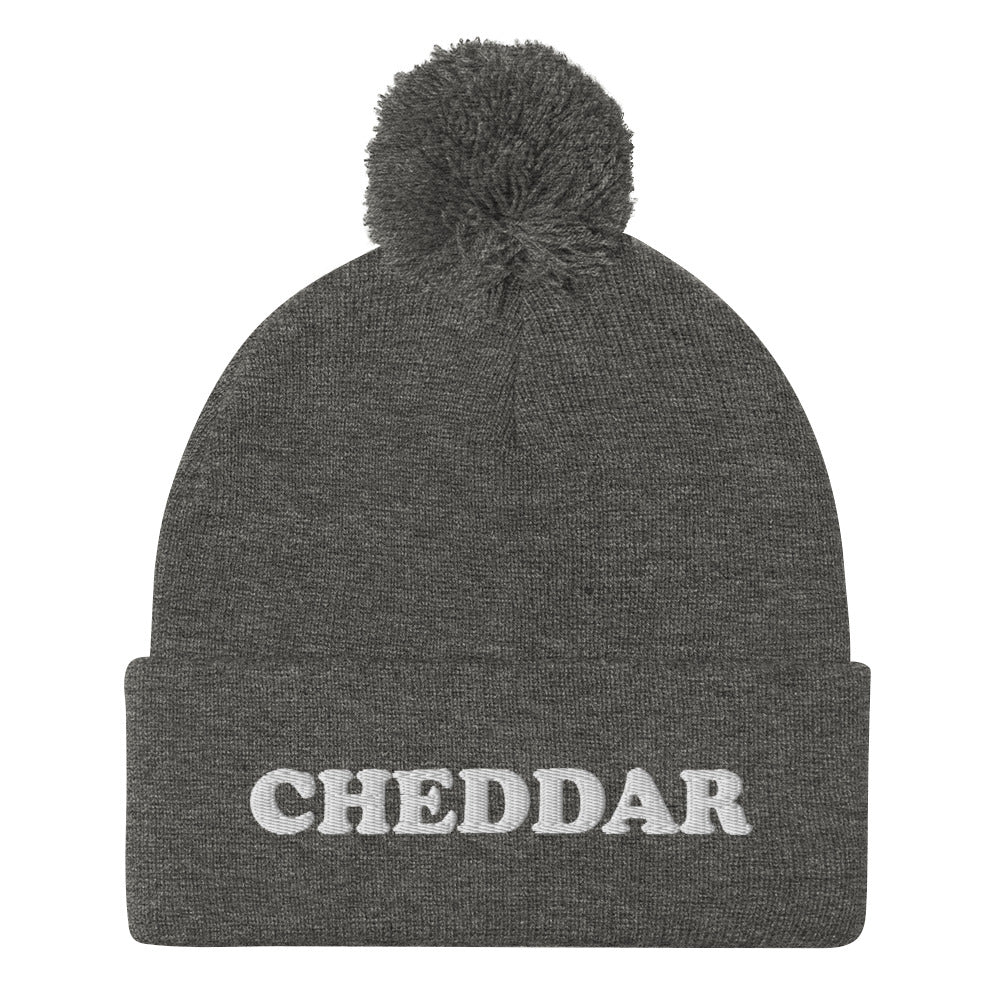 Gray Do you love cheddar cheese? Looking for a funny foodie gift? This warm and cozy, embroidered beanie is just what you need. It's a classic pom pom beanie with "Cheddar", expertly embroidered on the front. The perfect funny beanie for cheese lovers, cheddar enthusiasts and foodies of all kinds.