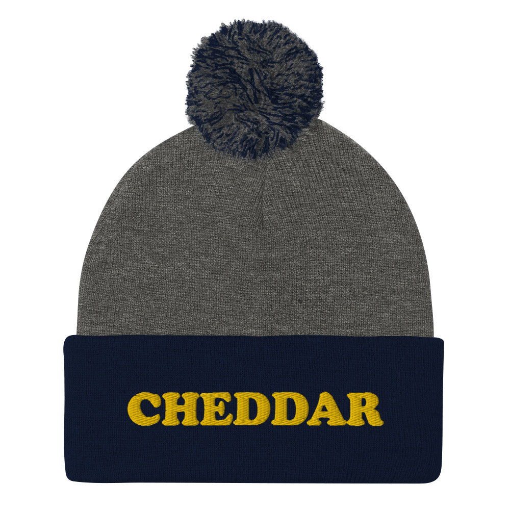 Navy and Gray Do you love cheddar cheese? Looking for a funny foodie gift? This warm and cozy, embroidered beanie is just what you need. It's a classic pom pom beanie with "Cheddar", expertly embroidered on the front. The perfect funny beanie for cheese lovers, cheddar enthusiasts and foodies of all kinds.