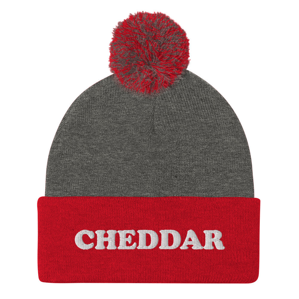 Gray and Red Do you love cheddar cheese? Looking for a funny foodie gift? This warm and cozy, embroidered beanie is just what you need. It's a classic pom pom beanie with "Cheddar", expertly embroidered on the front. The perfect funny beanie for cheese lovers, cheddar enthusiasts and foodies of all kinds.