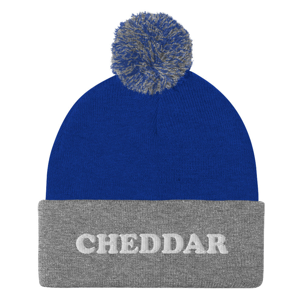 Gray and Royal Blue Do you love cheddar cheese? Looking for a funny foodie gift? This warm and cozy, embroidered beanie is just what you need. It's a classic pom pom beanie with "Cheddar", expertly embroidered on the front. The perfect funny beanie for cheese lovers, cheddar enthusiasts and foodies of all kinds.