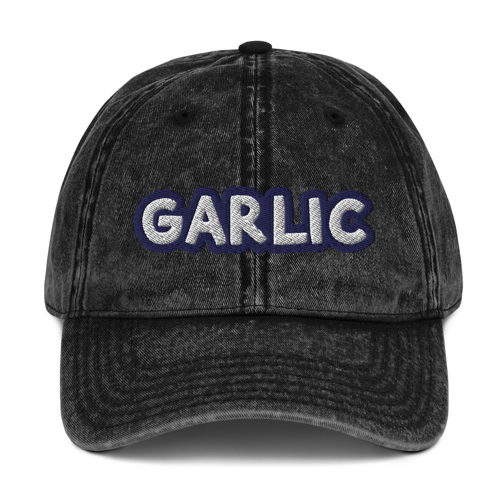 Black garlic dad hat from Nina's Funky Shop by ninanush - If you're a garlic lover, this funny food hat was designed just for you. Eat garlic in style and make a statement in this stand out foodie dad hat. It's a garlic lover hat that's made of cotton, with a washed out vintage style and an eye-catching blue and white embroidery. Perfect for garlic enthusiasts and foodies of all kinds.