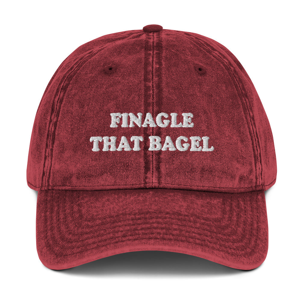 Maroon Finagle That Bagel Hat - Love Bagels? Looking for a funny gift for a bagel enthusiast? This Unique Bagel Hat is just what you need. It's comfortable, has an adjustable closure, and comes in a variety of colors with "Finagle That Bagel", on the front. Eat your favorite bagels in this funny food dad hat. Perfect for bagel lovers and beyond.